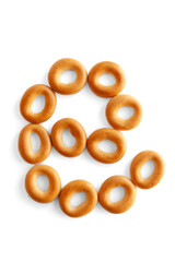 Symbol @ bagel. Bagels font. Alphabet from set of small dry bagels isolated on white background. ABC symbols.