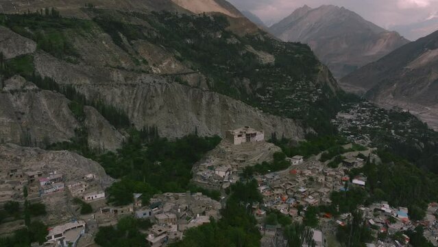 Aerial shot of Baltit Fort, Hunza, Pakistan. Dolly, drone flights forward toward the fort. Himalayas, sunset, golden hour