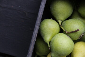 Pears in a wooden box on a vintage table.