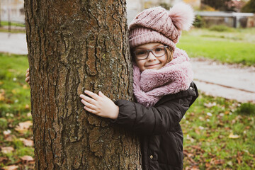 Dziewczynka zima - spacer - kocha drzewa - dziecko i zimowy spacer  - obrazy, fototapety, plakaty