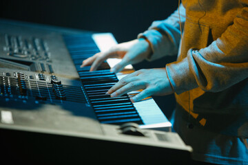 Musician plays music on electronic piano device on stage. Pianist playing live set on concert with...