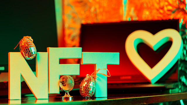 NFT inscription in neon light. NFT lettering at workplace with globe and shiny eggs. Creative concept NFT trend - Powered by Adobe