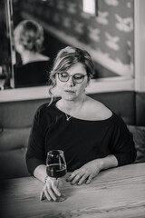 Women alone sit in restaurant drink wine