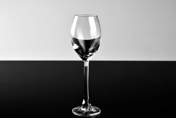 Fototapeta pusty kieliszek do wina na białym i czarnym tle, czarno-białe tło i szkło obraz