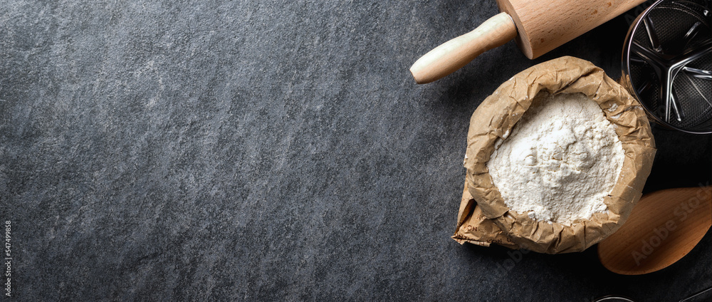 Aufkleber paper bag of flour on dark background with copy space top view. bakery background