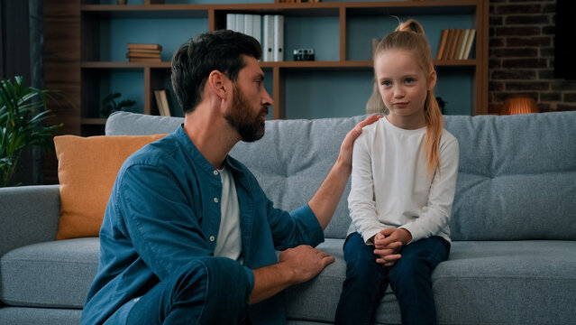 Loving Caring Father Dad Babysitter Parent Apologize To Offended Daughter Girl At Home Professional Psychologist Man Talk With Naughty Upset Child. Two Diverse People Have Quarrel Conflict In Family