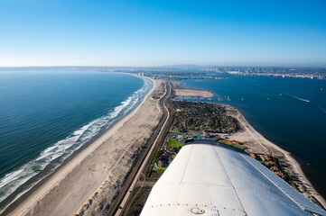 Fototapeta na wymiar Aerial view from a plane of Silver Strand Beach in San Diego California with boats in the water