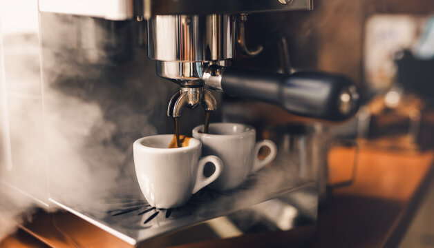 Portafilter machine pours fresh coffee into espresso cups