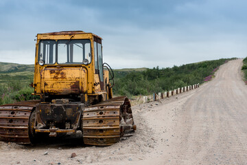 yellow bulldozer, on a dirt road in the tundra