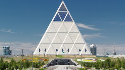 Exterior of the Palace of Peace and Reconciliation building timelapse with park and fountains near by. Nur-Sultan city, Kazakhstan.