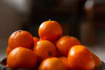 Basket with tangerine or orange fruit on a gray plaid background.