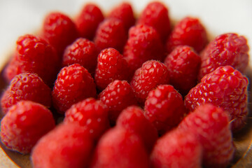 Raspberry close-up on a beautiful stand, summer fruit. Fruits are good for health. Proper nutrition, raw food.