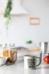 Mug of morning coffee on white tile tabletop in kitchen. Healthy breakfast consept with coffee, oats and apple. Domestic life. Text space