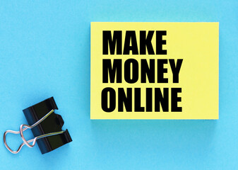 MAKE MONEY ONLINE words on a small piece of paper and blue background.