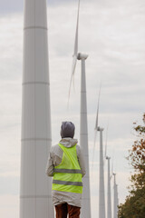 female engineer in a protective vest takes measurements of the speed of wind turbines. electricity is generated by wind. technologies without an eco trace. engineering solution. generating electricity