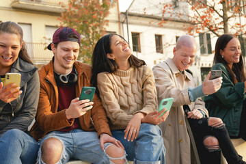 Group of urban friends using smartphone at urban place outdoor, Young people sharing content with...