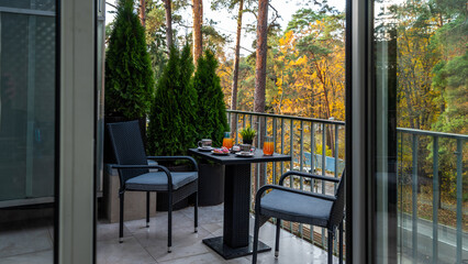 Plakat Cozy balcony terrace of luxury private house. Cottage near autumn forest. Grey table and chairs. Drinks and sweets.