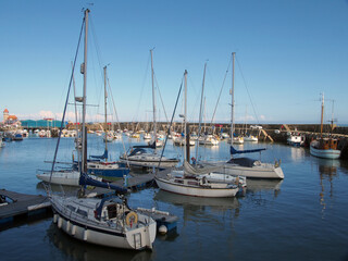 Fototapeta na wymiar boats and yachts moored in marina section of scarborough harbour in summer sunlight