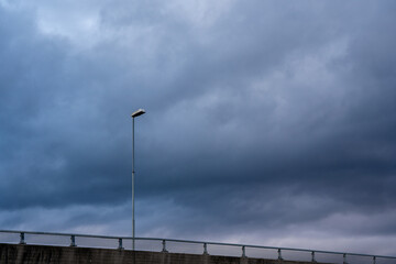 a dramatic blue autumn sky with some dark dramatic clouds but in the middle a large lantern on a...