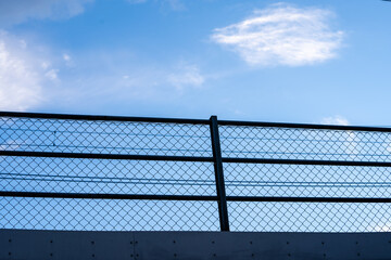 blue beautiful bright sky with a metal railing visible below it