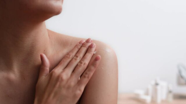 A woman's hand makes a body massage moisturizing her skin with an organic cream to restore and remove skin defects, natural daily care for her body
