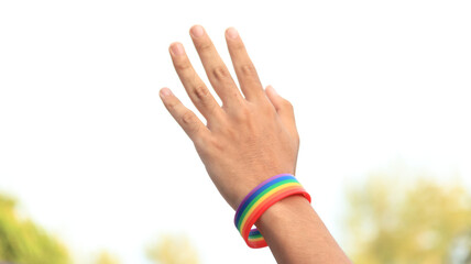 Hands have rainbow wristbands on making sign to show love in LGBT pride concept