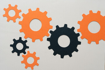 black and orange paper cogwheels on blank paper