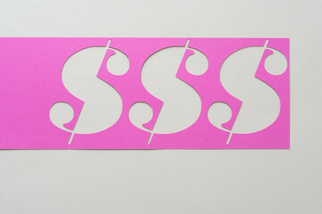 pink paper stencil with dollar or currency sign cutouts