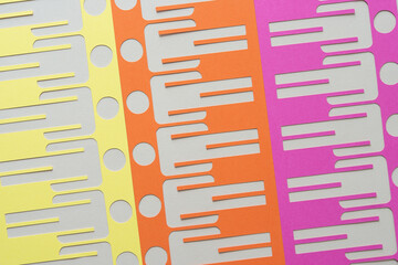 yellow, orange, and pink paper stencils with stick figure glyph cutouts