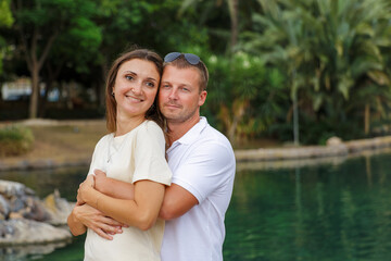 A couple in love hugs and walks in a city park, the relationship between a man and a woman