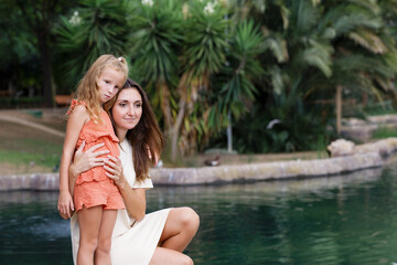 Obraz premium A mother with children walks in a city park, family vacation, the concept of a healthy lifestyle and family leisure