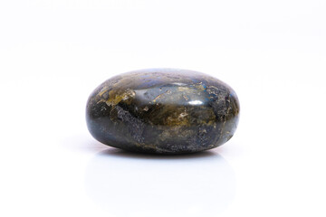 Natural gemstone labradorite isolated on white background. Dark gray labradorite with an inner iridescent glow on a white background