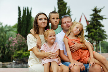 Family spending time together, cheerful parent with kids walking in the park in good weather