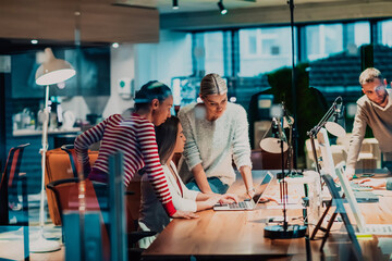 Three young women in a modern office solve a problem together while using a laptop