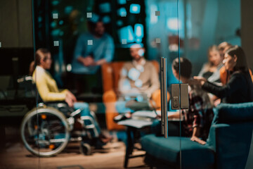 Fototapeta na wymiar Businesswoman in wheelchair having business meeting with team at modern office. A group of young freelancers agree on new online business projects