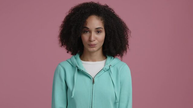 Close-up shot view of mixed-race, emotional woman looking at camera. Woman nodding and smiling, making a positive facial expression. High quality 4k footage