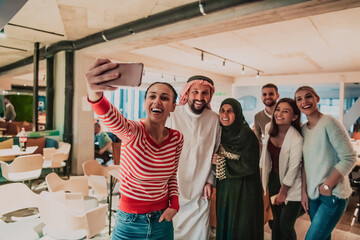 Diverse team of businessmen taking selfie photos on smartphone while in modern office