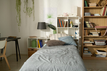 Horizontal image of child bedroom with modern design with cozy bed, bookcase and desk in the corner of room