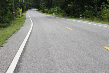 Fototapeta na wymiar Asphalt road curve in the forest