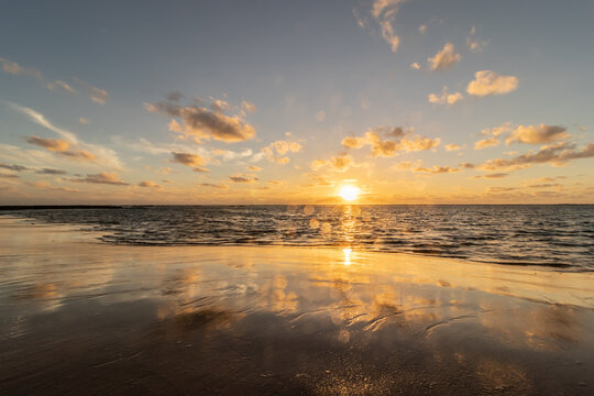 sunset reflection on the wet sand on tha beach