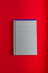 Open spiral bound notepad pen  on red background