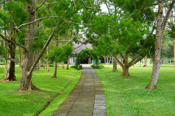 A walkway in a garden made of brick traverses the edge and amidst lawn or meadow in a flower garden. 
Tourist, travel, holiday and vacation spot Taman Bunga Nusantara, Cianjur, Indonesia