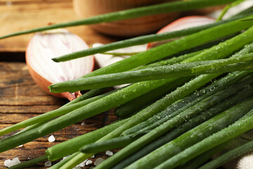 Fresh green onion on wooden table, closeup