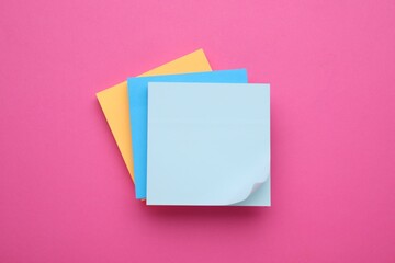 Colorful empty notes on pink background, top view