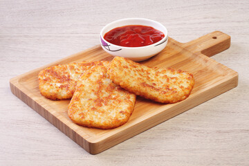 Hash browns on wooden cutting board 