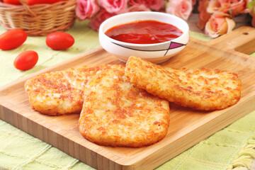 Hash browns on wooden cutting board 