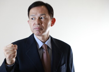 Middle-aged Japanese male businessman wearing navy blue suit on white background. Conceptual image of a project proposal, strategic business success and negotiation closing.