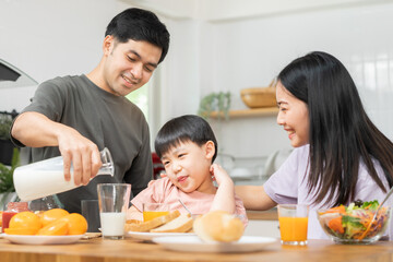 Happy refreshment family breakfast in morning, asian young parent father, mother and little cute boy, child having meal in kitchen eating together at home. Cheerful, enjoy cooking people.