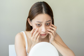 Bored, insomnia asian young woman, girl looking at mirror hand touching under eyes with problem of...