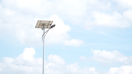 Solar street light lamp post led with panel system on the road with blue sky and tree for background energy saving concept.